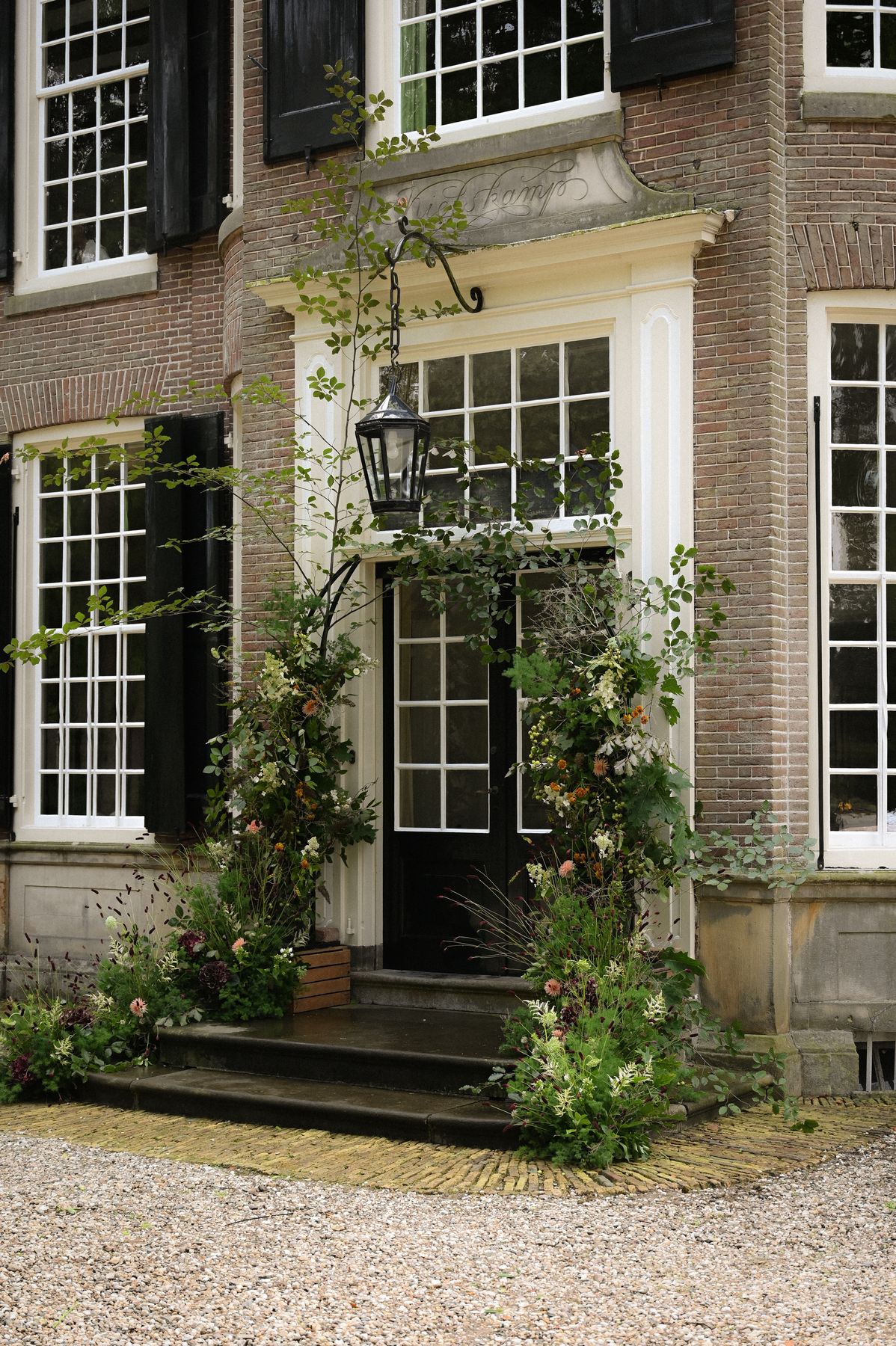 Bloeminstallatie rond de entree van een historische gevel