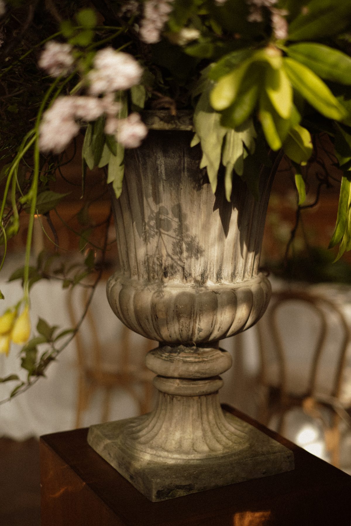 Detail van een stenen urn met bloemen