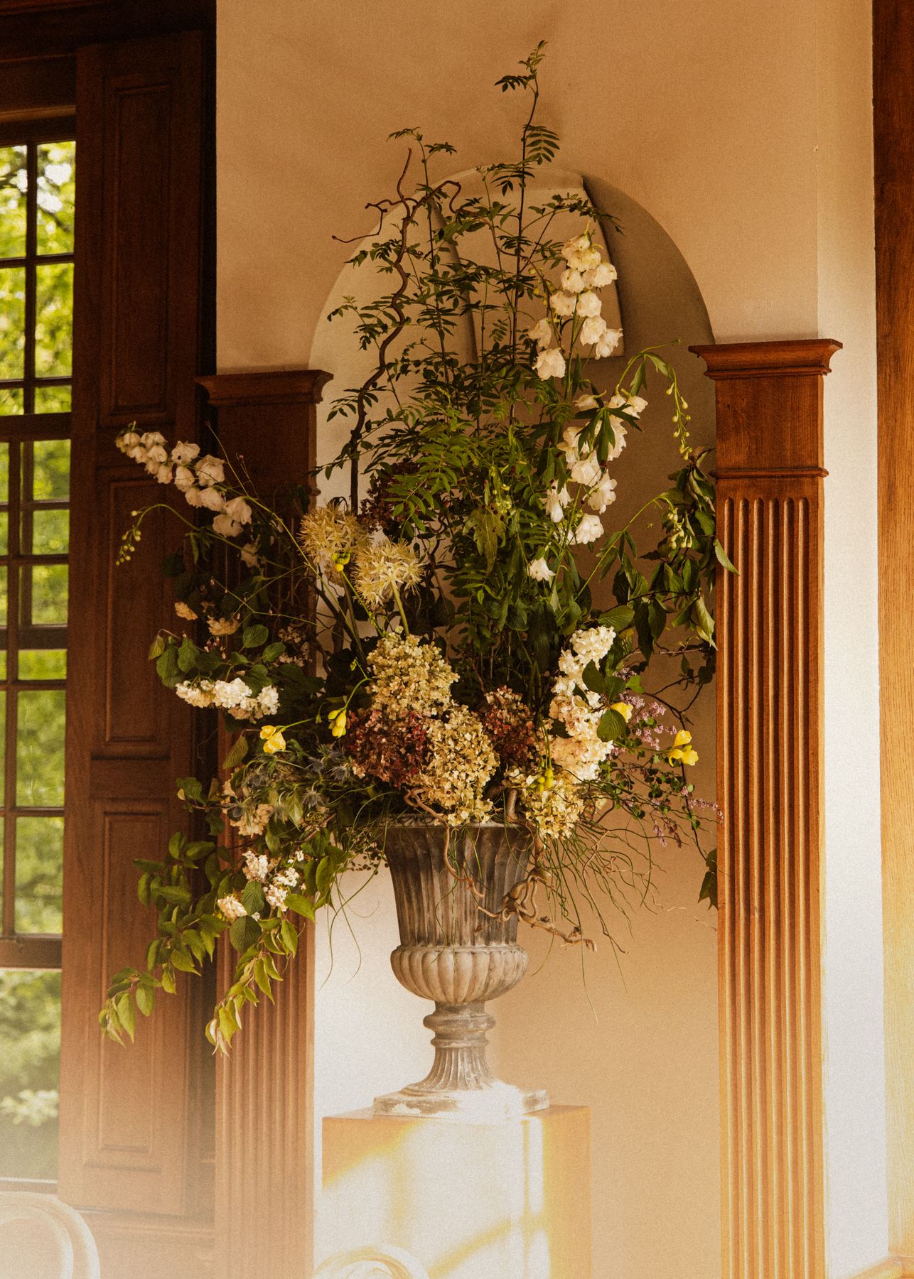 Urn met bloemen in een interieur bij avondlicht