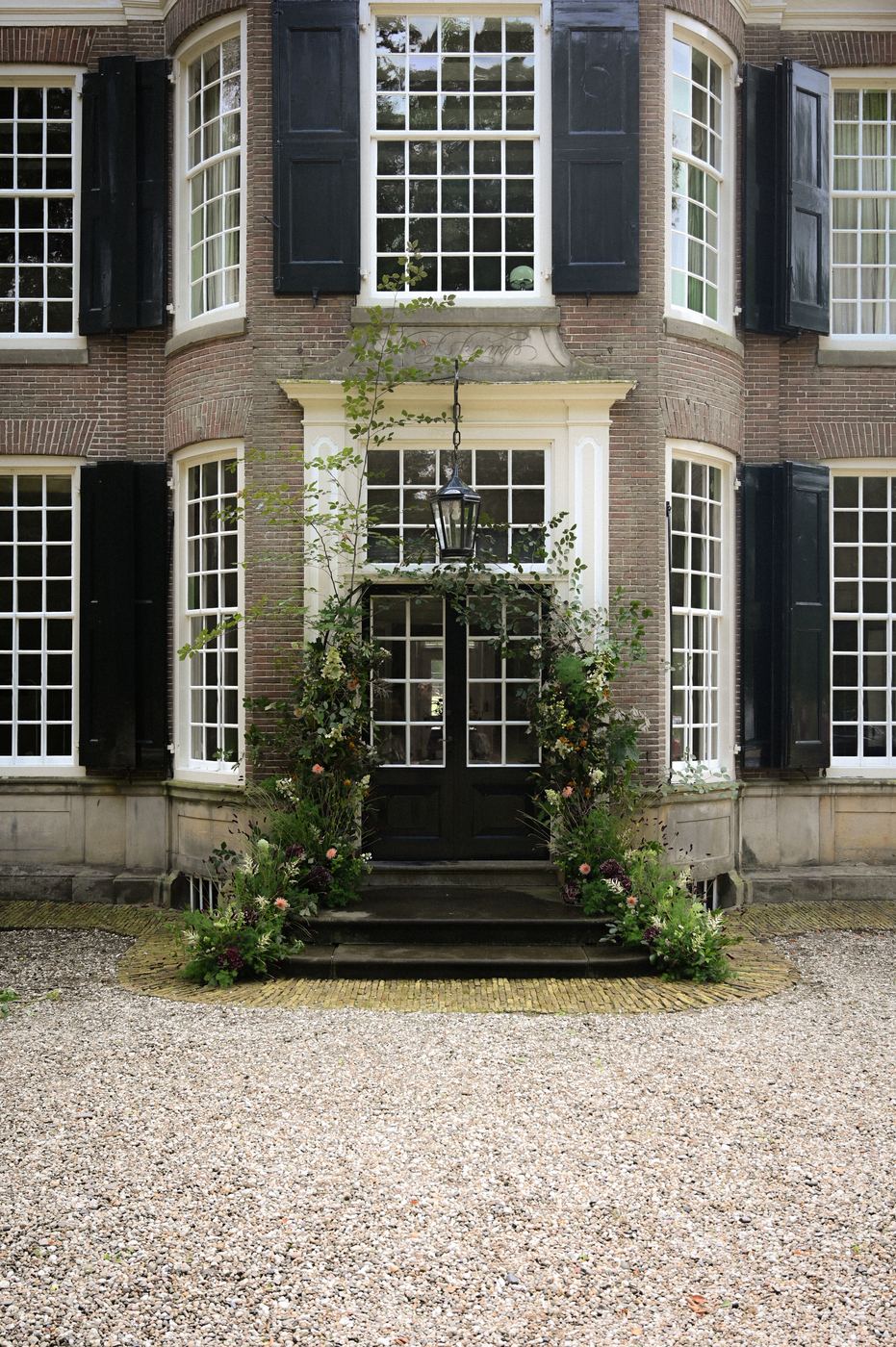 Bloeminstallatie rond de voordeur van een historisch landhuis