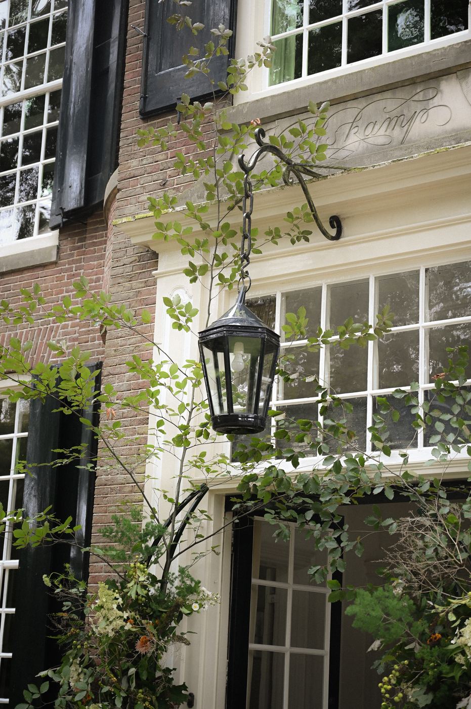 Takken en een lantaarn langs een gevel